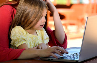 Lapsi ja vanhempi tietokoneella.
