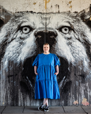 Nainen seisoo susi-grafiitin edessä.